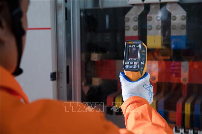 Công nhân EVNHANOI kiểm tra tủ điện nhằm phát hiện sớn các nguy cơ phát sinh sự cố thông qua thiết bị đo nhiệt.( Ảnh: Quốc Lũy/TTXVN)